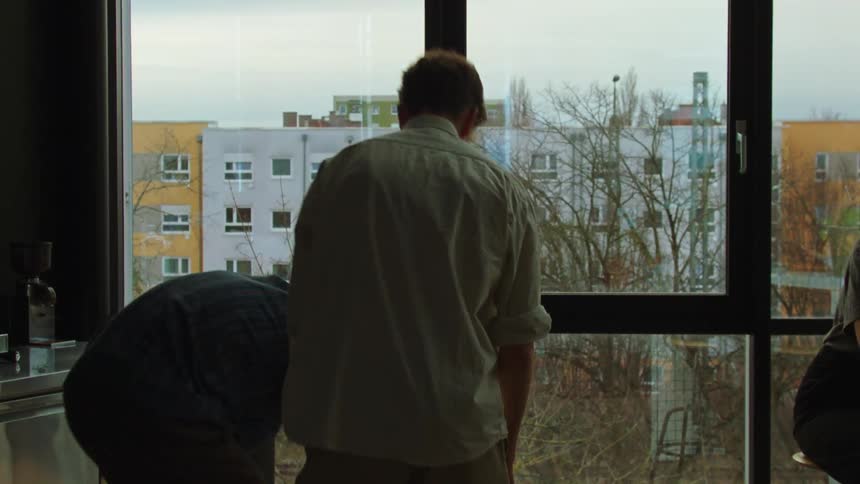 A man rehearses something walking around bumping into his room mate