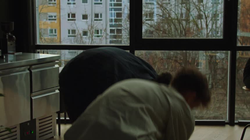 Closeup of a persons legs walking in a circle and then bumping into another person and knocking over documents