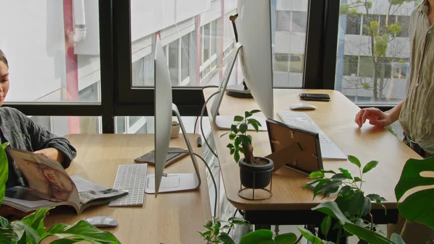 A person adjusting a standing desk at the office