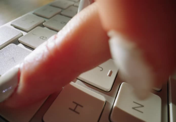 A person is typing quickly on a computer keyboard