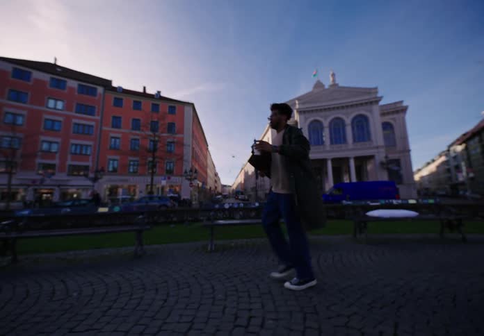 Man runs with a cup of coffee on the city at morning