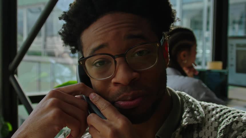 Close up of a young man talking on the phone in the office