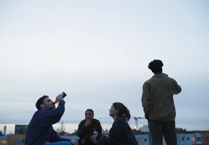 A group of friends drinking beer and playing rock paper scissors