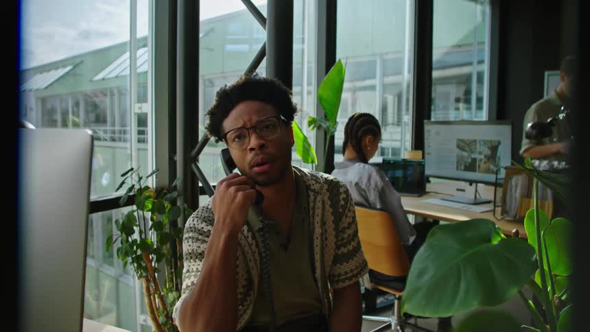 A man working at the office receives a distressing phone call