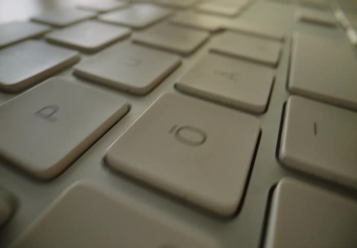 Extreme closeup on a white keyboard with sun glare