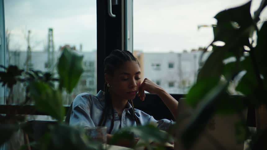 A female employee in an office tiredly leans her head against her hand