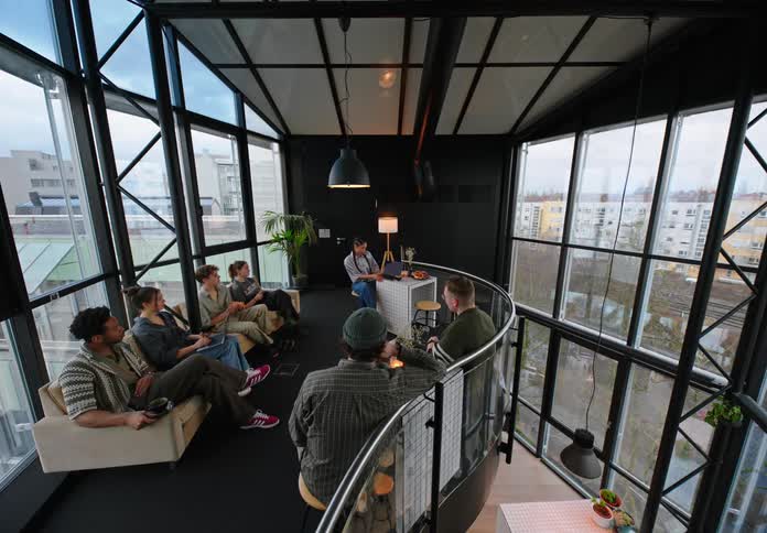 Employees sit in an office listening to someone speak