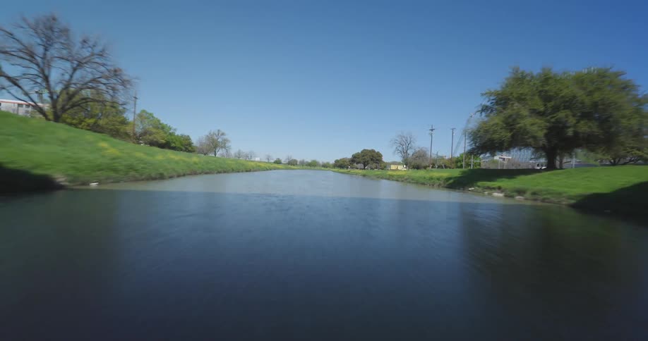 Panorama of a river next to a park in a metropolis during the day in the cloudless blue sky