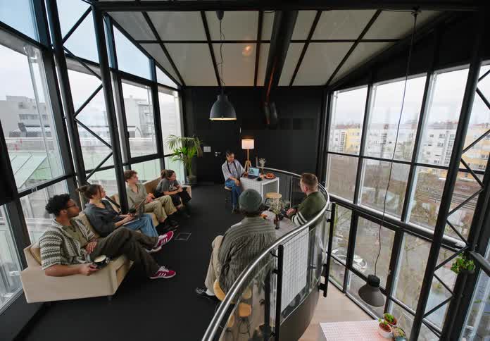 Group of people sitting in a meeting in an office inside a mirrored building