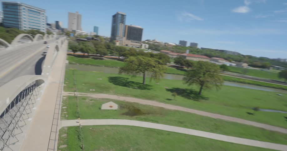 Aerial view of a bridge over a park under a blue sky