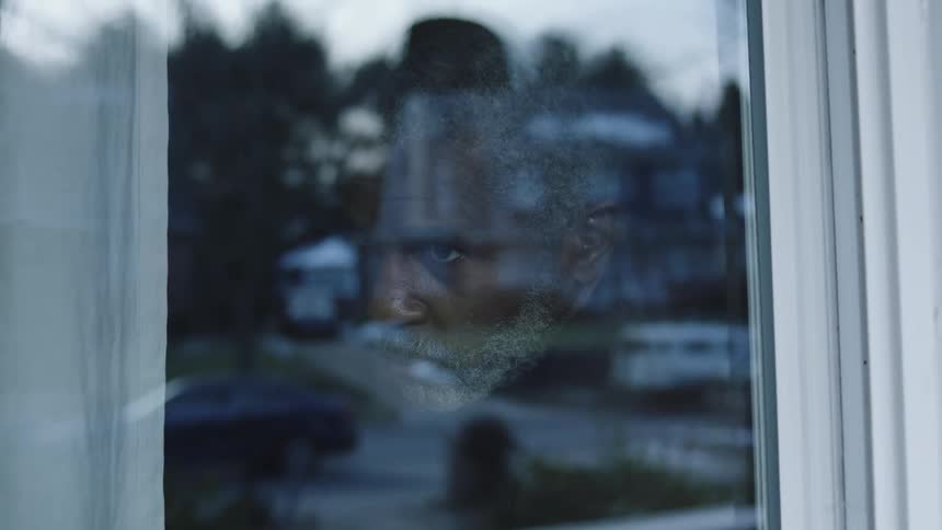 A footage of a man sitting beside the window