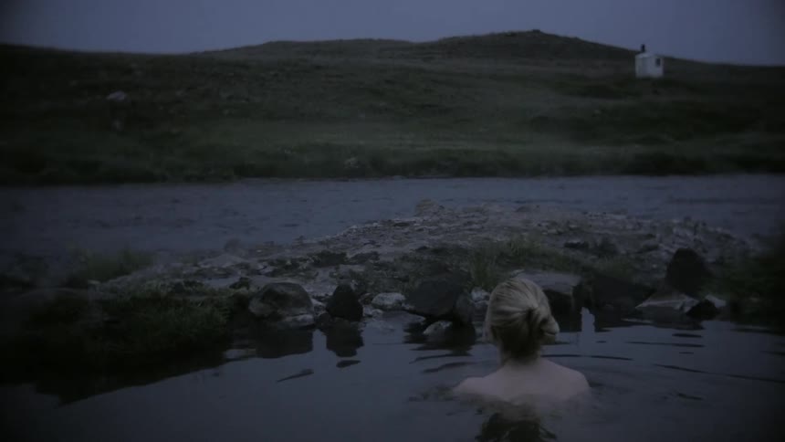 A woman taking a bath on a natural pool next to a river