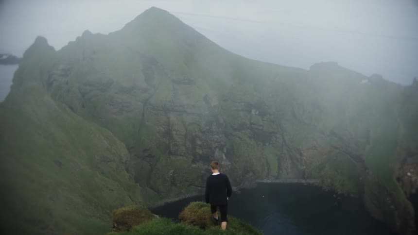 A male is hiking through a mountainous landscape