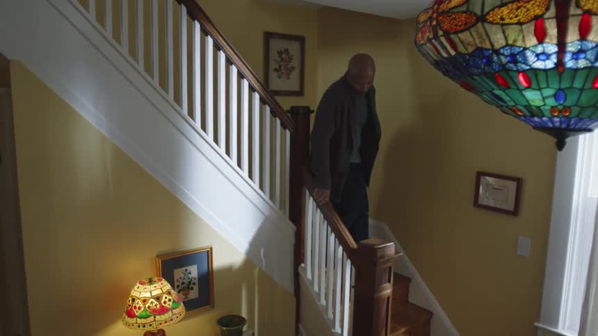 Man walking down the stairs at home slowly during the day