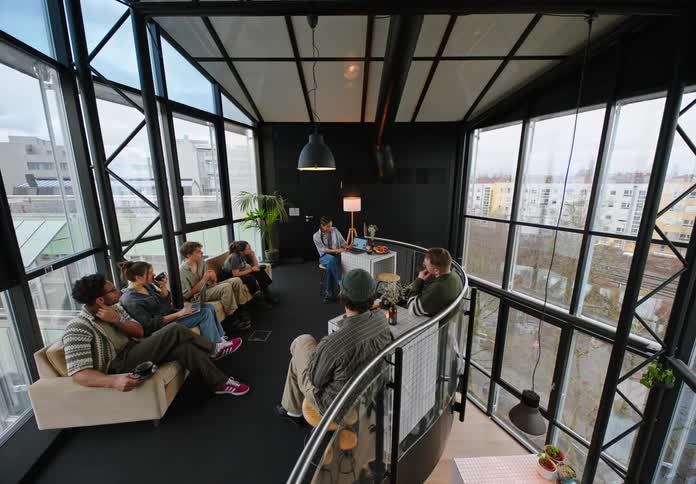 Group of people sitting and paying attention to a woman talking while in an office building