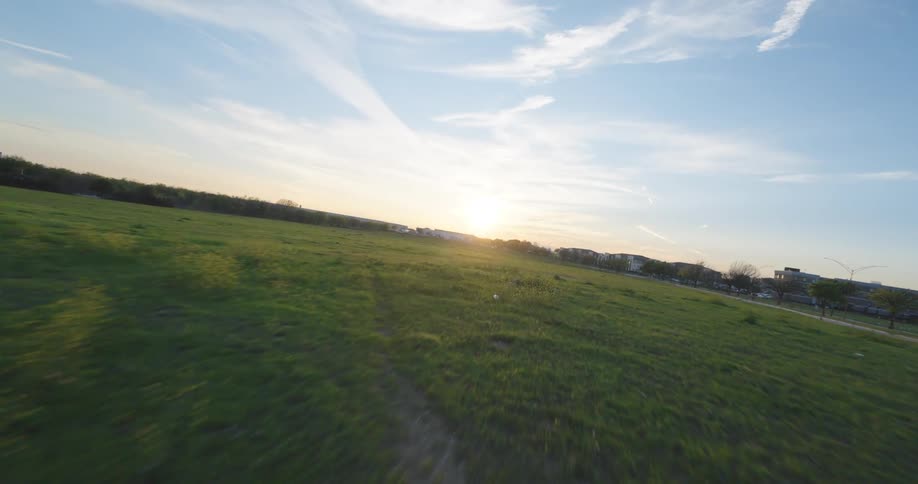 Aerial view of the sun rising over a field on a farm