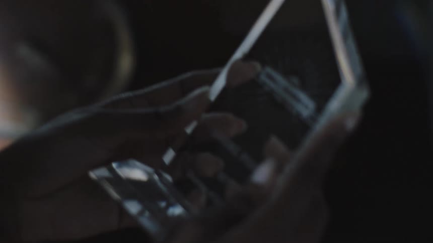 A man packs a small clear trophy on a cardboard box