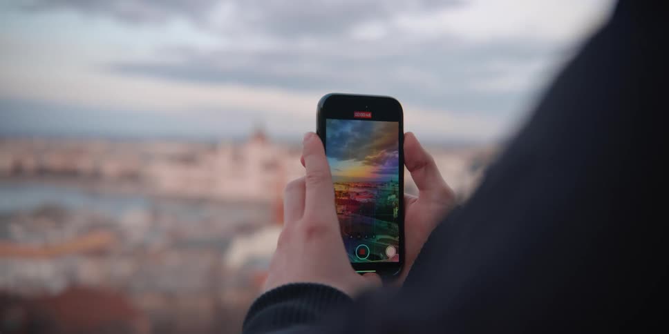 Person records riverside scenic view of Budapest with a smartphone