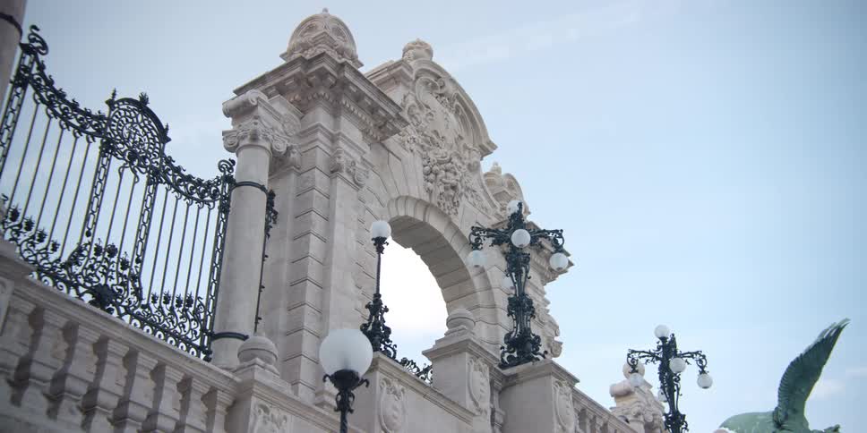Person walks near large arched Buda Castle Gate in Budapest