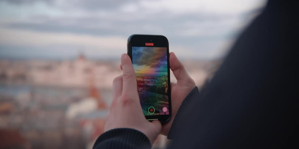 A person films panorama of Budapest over Danube River with a smartphone