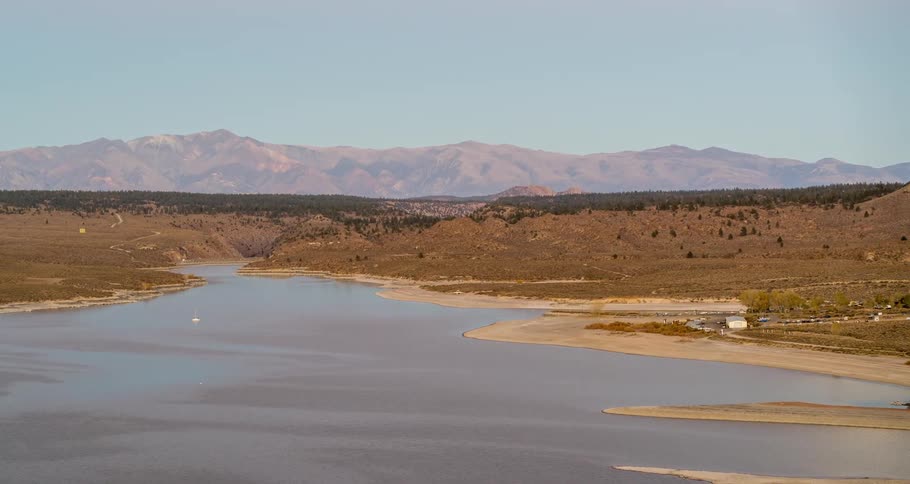 Aerial view of a lake in a desertic area next to the mountains