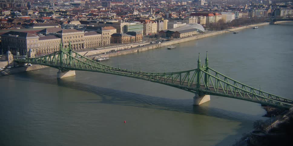 Cars drive over Liberty bridge and the Danube River toward Budapest