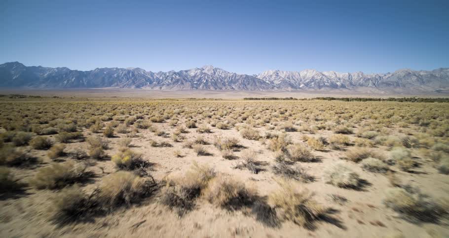 A mountain range is at the end of the desert