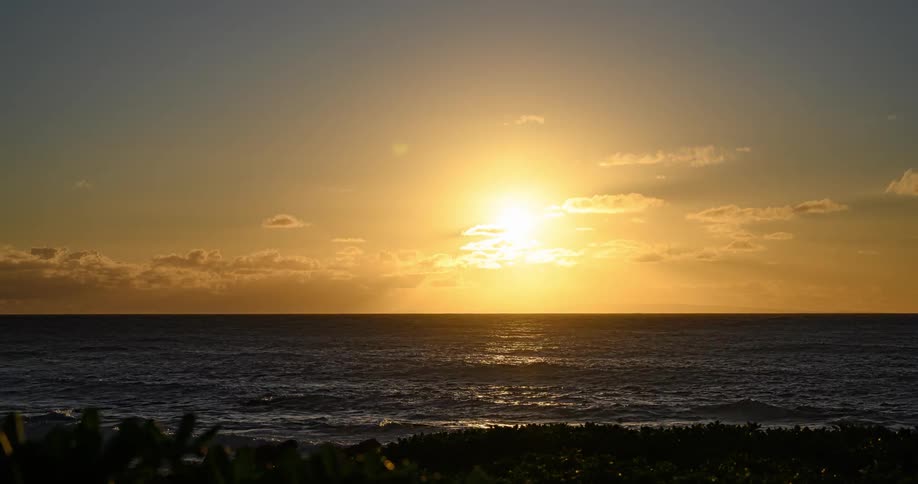 Time lapse of the sun rising over the clouds across the ocean