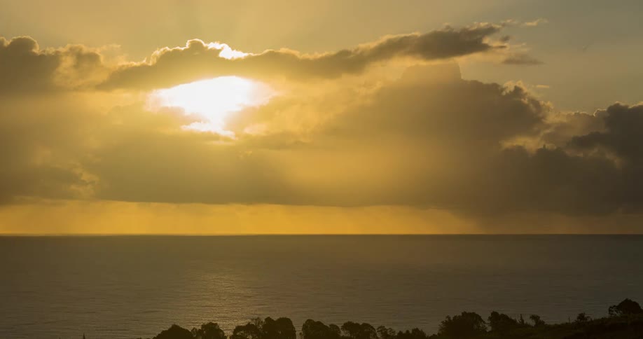 The sun rises off the coast as a storm occurs