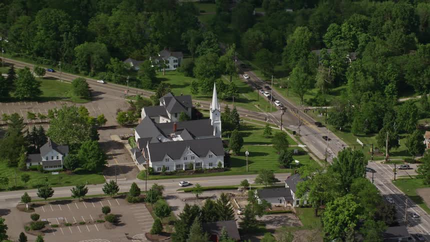 Cars drive around a church in suburban area