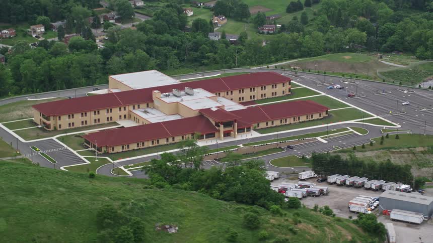 Aerial panorama of a complex with two pavilions next to hills and residential neighborhoods