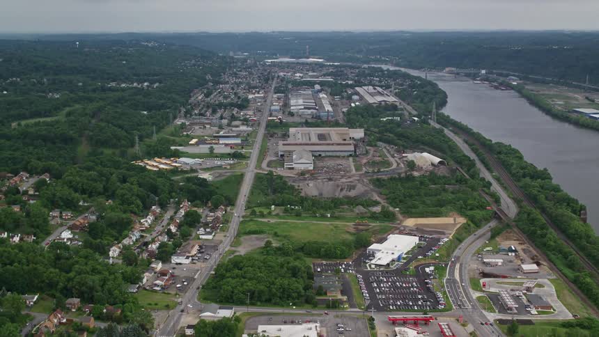 Aerial panorama of an urban city with residential neighborhoods factories and the edge of a river canal