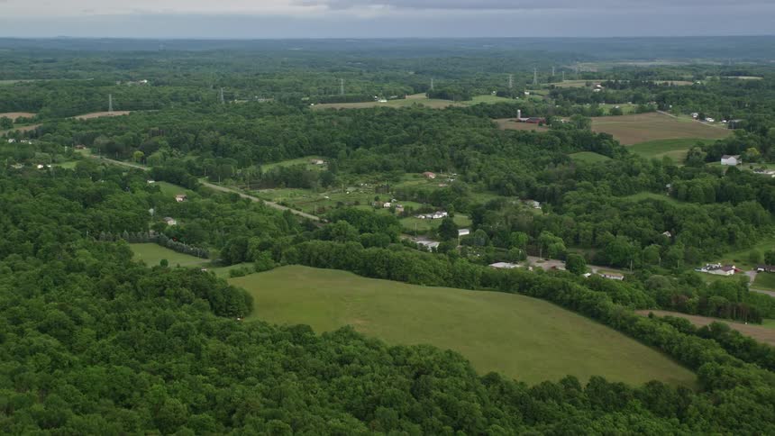 An aerial view of a lush green countryside with winding roads and fields
