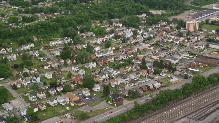 Aerial panorama of an urban and residential city on the edge of a highway and train tracks