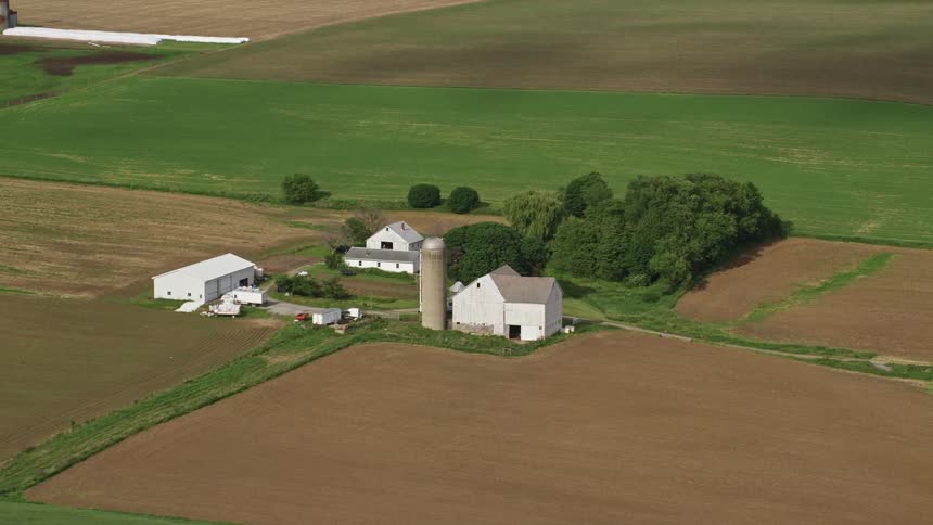 A farm nestled near a grove of trees