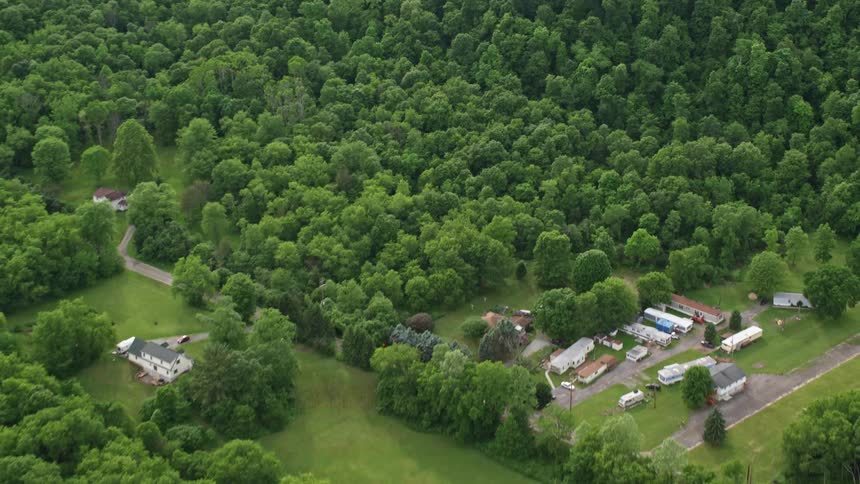 Aerial panorama of mountains and hills covered by forests and some houses in rural areas