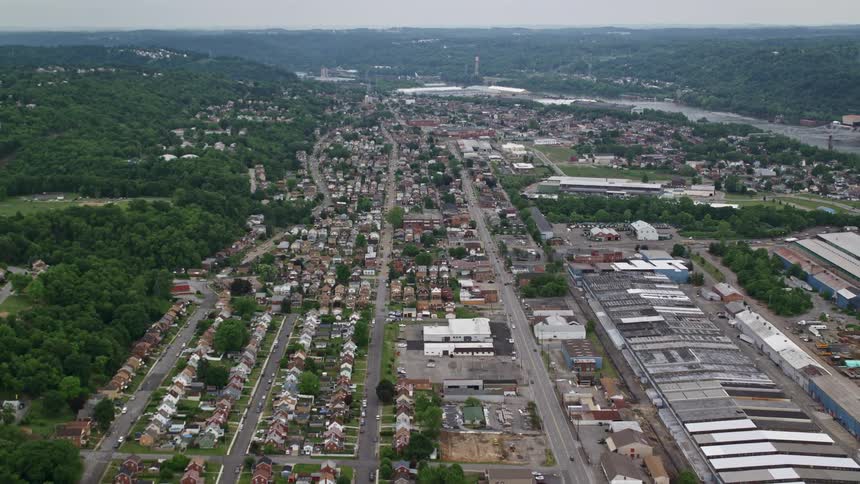 Aerial panorama of an urban city with residential neighborhoods factories and the edge of a river canal