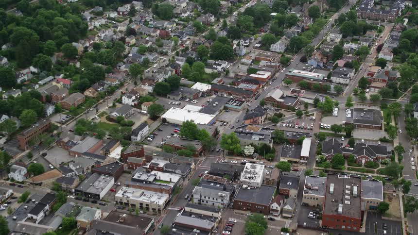 Aerial of businesses and neighborhoods in a small town on a summer day