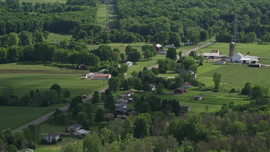Aerial panorama of houses in rural areas and on the edge of a highway busy with vehicle traffic