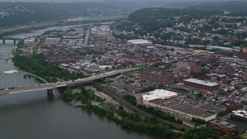 An aerial view of a bridge over a river in a city at dusk