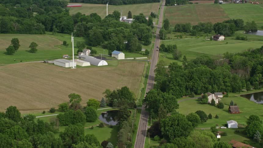 A road runs through a rural area filled with farms