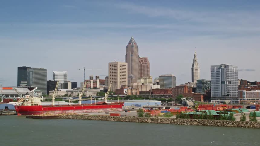 Aerial panorama of a metropolis with skyscrapers on the seafront with a port with boats and containers