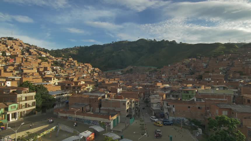 Aerial view of a highly populated slum between the mountains at sunrise