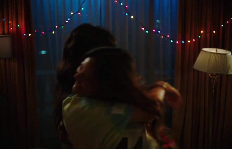 Two young women dancing holding each other and laughing