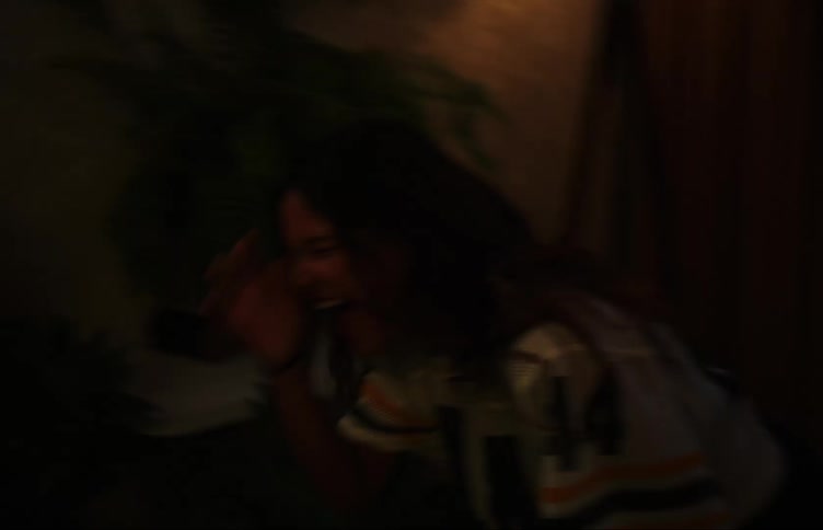 Two teenage girls dancing in a dimly lit room with colorful lights