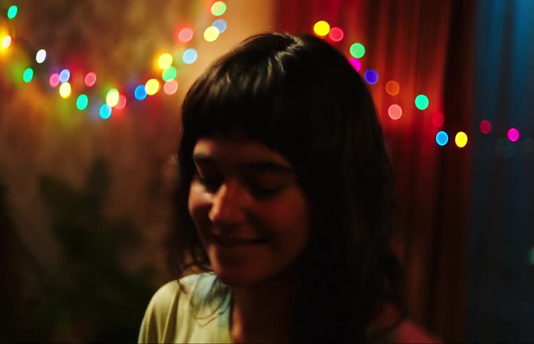 A young woman smiling and dancing at home with someone else