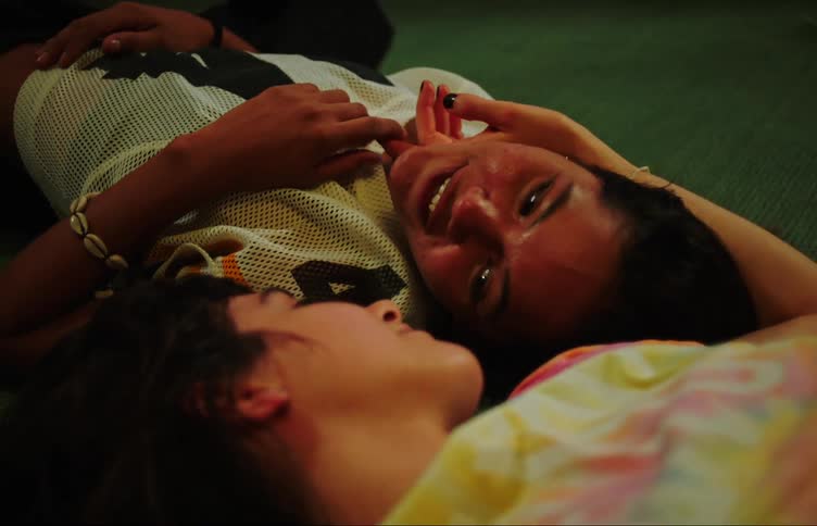 A couple of teenage girls talk on he floor of the living room
