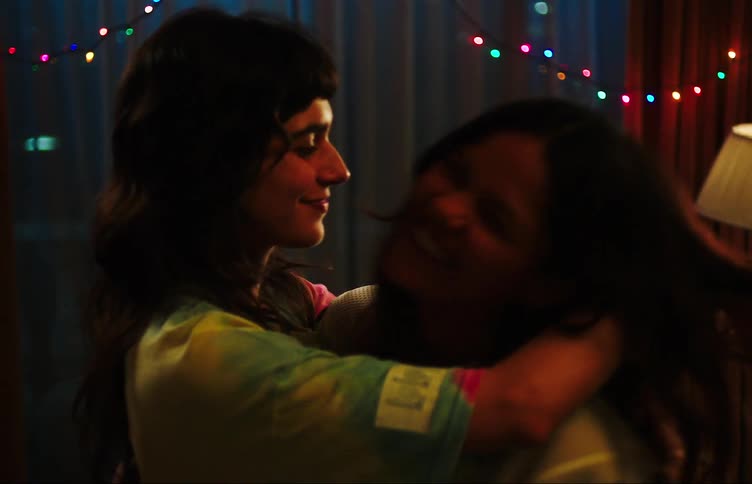 Young women in the room dancing and hugging each other warmly