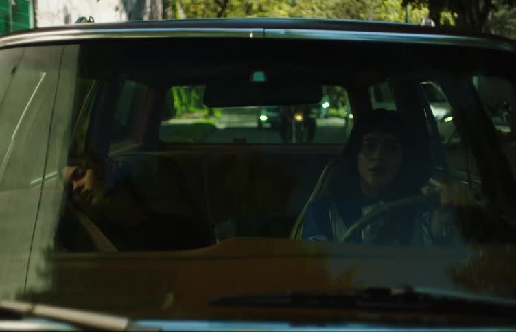 Two young women in a car one driving and the other sleeping on the passengers seat