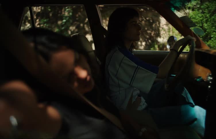 Woman driving a vehicle while her colleague next to her in the passenger seat is sleeping